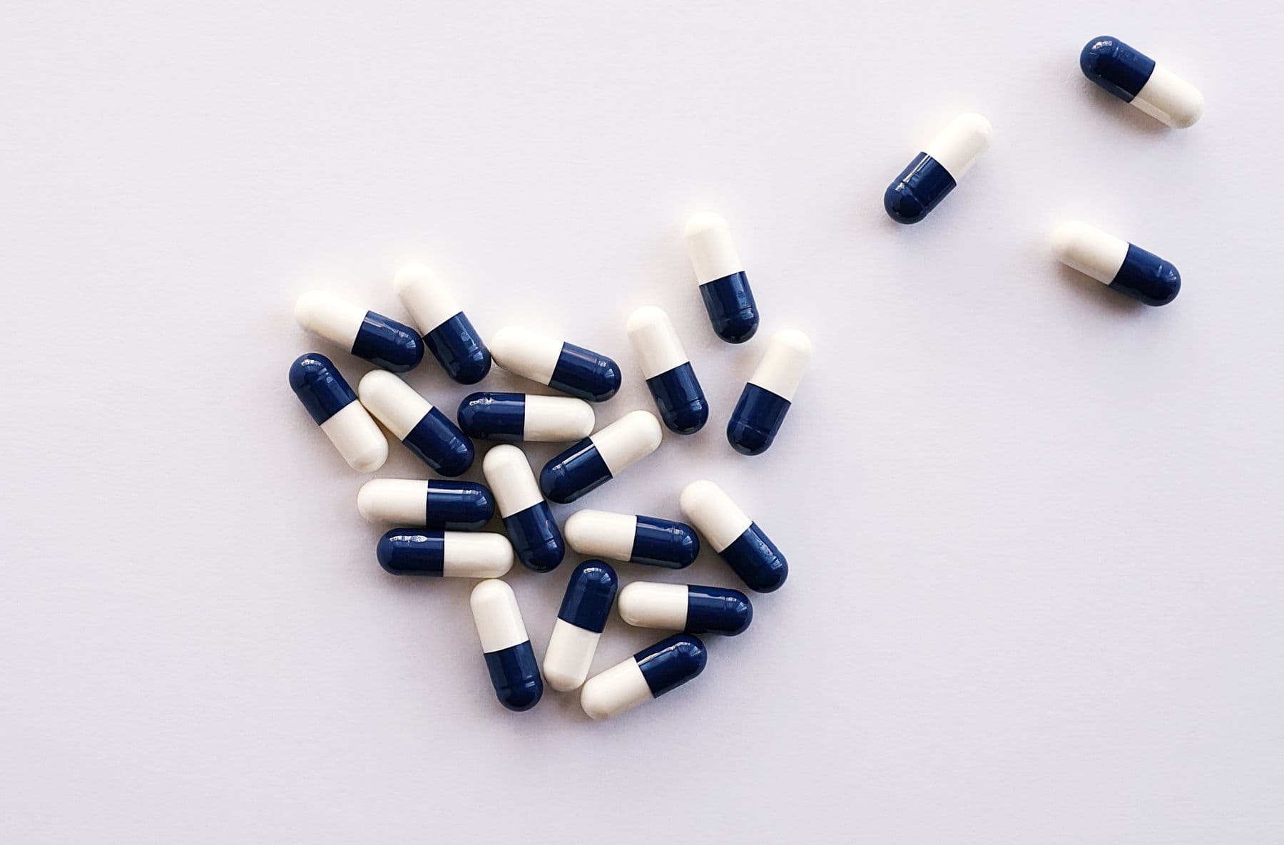Medication capsules arranged for a pharmacy still life. Demonstration imagery — not Peak Mark inventory.