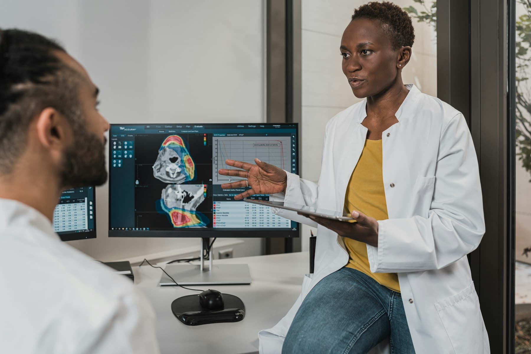 A clinician discussing imaging results during a care conversation. Demonstration imagery — not Peak Mark staff.